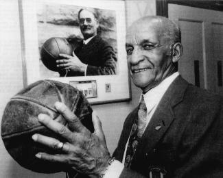 John B. McLendon, Jr. poses in front of Dr. James Naismith.